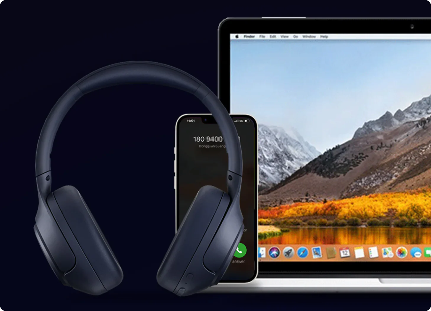 Casque audio circum-auriculaire bleu foncé à côté d’un iPhone et d’un MacBook avec un paysage de montagne en arrière-plan.
