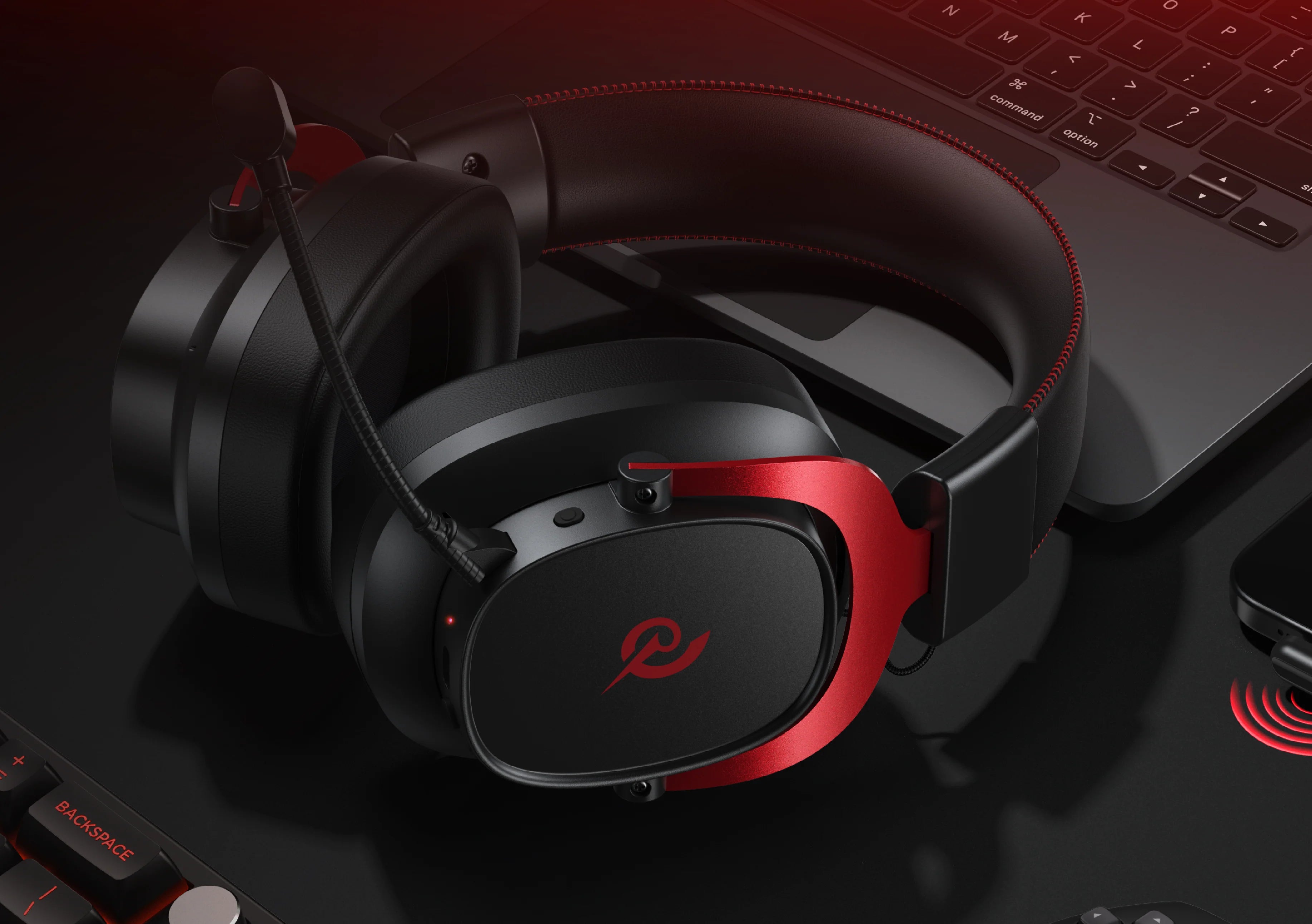 Casque de jeu avec accent rouge et microphone, posé sur un ordinateur portable, pour une expérience audio optimale lors du jeu.