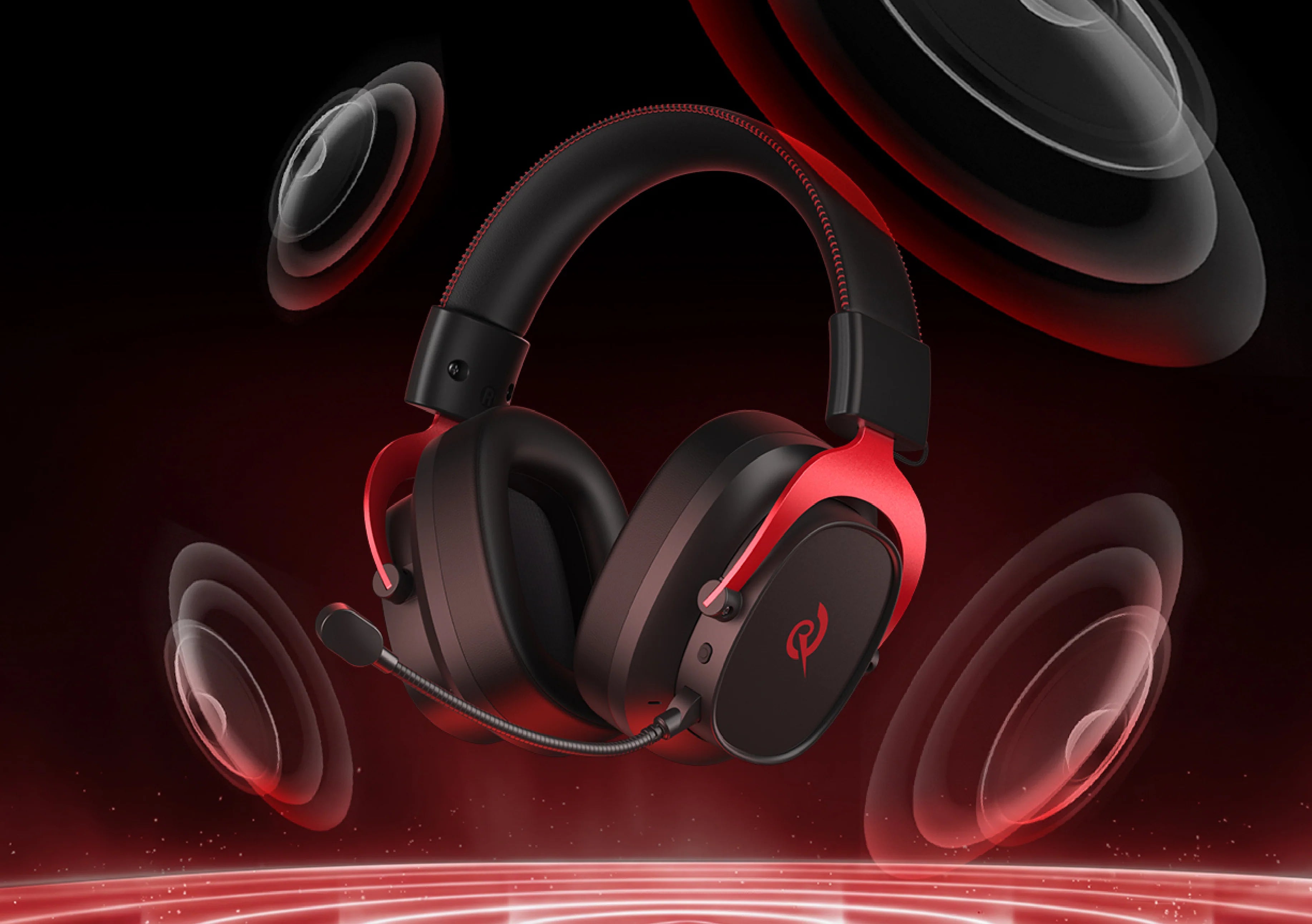Casque de jeu noir avec des accents rouges et un microphone, entouré d'enceintes dynamiques sur un fond sombre.